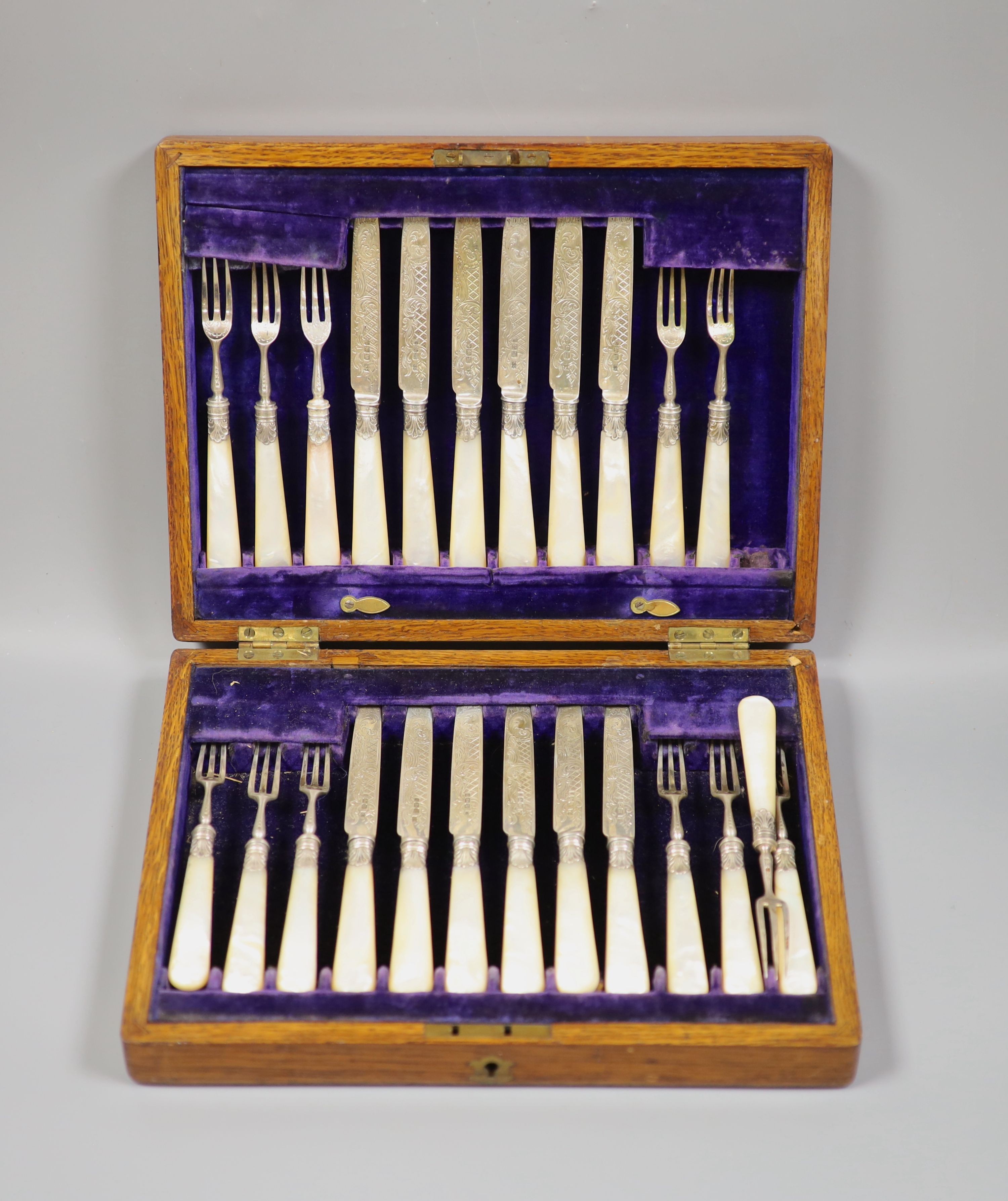 An Edwardian cased set of twelve pairs of mother of pearl handled silver dessert eaters, John Sanderson, Sheffield, 1904.